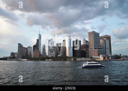 Eine Yacht, vorbei an Lower Manhattan in der Upper Bay, New York, Vereinigte Staaten Stockfoto
