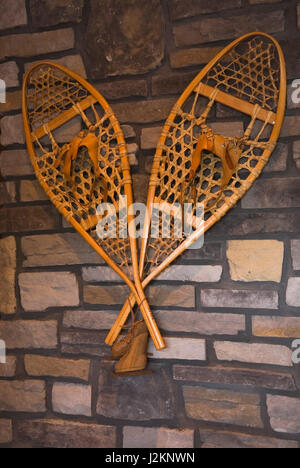 Holz- und Spitze leder Bindungen Schneeschuhe hängen an Natursteinmauer im Familienzimmer im Erdgeschoss im Landhausstil Wohnung anmelden Profil Startseite. Stockfoto