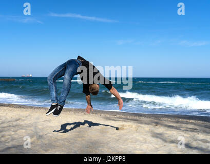junge Parkour Mann tut Flip oder Salto Stockfoto