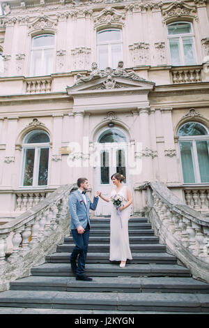 Attraktive frisch verheiratete Paar hinunter über eine alte Treppe in der Nähe der alten österreichischen palace Stockfoto