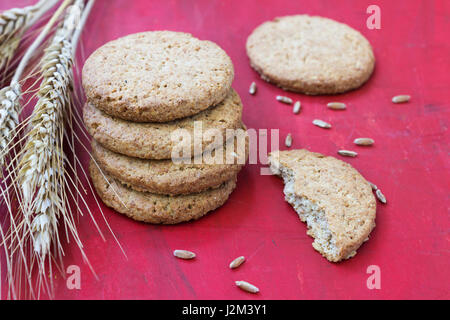 Cookies gemacht von Vollkorngetreide auf rotem Grund Stockfoto