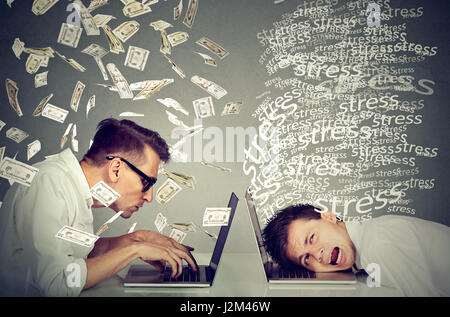 Mitarbeiter Einkommen Entschädigung Wirtschaft Konzept. Betonte verzweifelten Mann arbeiten am Laptop sitzt neben junger Mann unter Geld-Regen. Arbeit Differenc zu zahlen Stockfoto