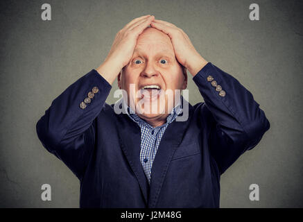Erstaunt, überrascht, älterer Mann auf grauem Hintergrund isoliert Stockfoto