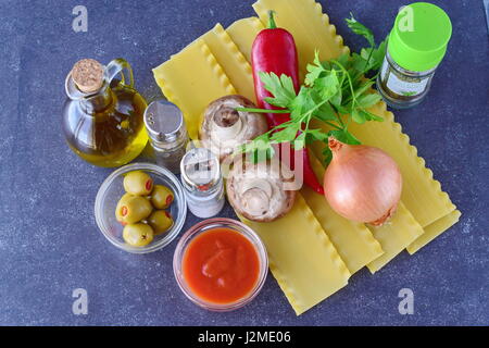 Kochen vegetarische Lasagne in Rollen mit Champignons, Paprika, Oliven, Tomatensauce. Reihe von Zutaten. Gesunde Ernährung. Vegetarisches Essen. Schritt für Schritt kochen. Stockfoto