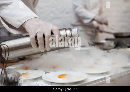 Chef kocht Eis mit Früchten mit flüssigem Stickstoff, catering, Nahaufnahme der Hände Stockfoto