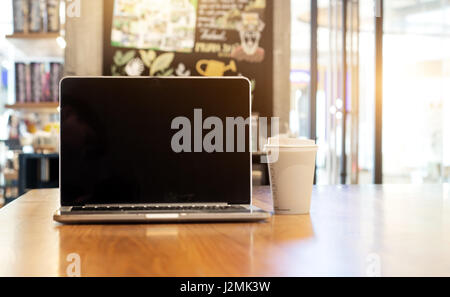 Wählen Sie Schwerpunkt leerer Bildschirm Monitor Notebook auf Holz Tisch im Café für advrtising Stockfoto