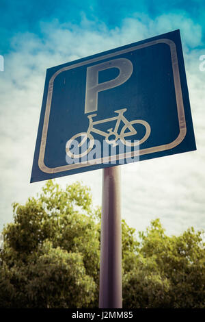 Fahrrad-Parken Zeichen auf blauem Himmel und Baum mit filter Stockfoto