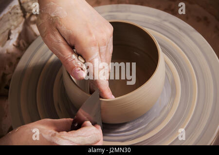 Nahaufnahme von den Händen der Keramikerin in seiner Töpferscheibe arbeiten. Stockfoto