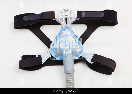 Schlafapnoe CPAP-Maske und Schlauch auf weißen Kissen Hintergrund mit CPAP-Gerät für Menschen mit Schlafapnoe oder Schlafstörungen Stockfoto