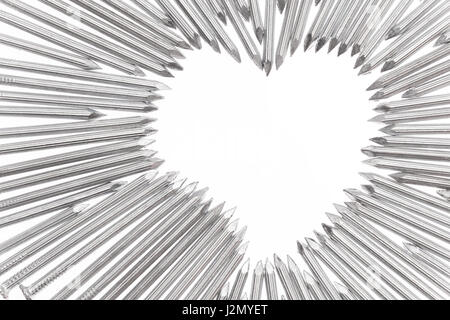 Stahlbeton Nägel zeigen die Spitzen in Richtung Herz Form leere Leerzeichen für Text in der aus der Mitte des weißen Hintergrundes Stockfoto