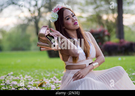 Philippinische Model südostasiatischen Schönheit mit einem lokalen Park als Kulisse, UK. Stockfoto