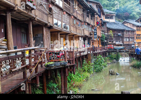 Zhaoxing, Guizhou, China, ein Dong Minderheit Dorf.  Häuser säumen den kleinen Fluss, der durch das Dorf. Stockfoto