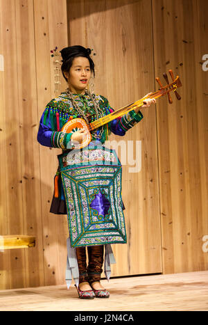 Zhaoxing, Guizhou, China.  Junge Frau von der Dong ethnische Minderheit spielt eine fünf-saitige laute (Pipa). Stockfoto