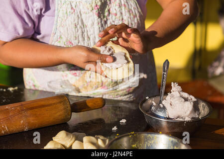 Frau macht Curry Blätterteig Füllung in den Teig hinzufügen Stockfoto