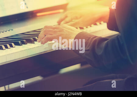 Pianist Hände spielt Klavier in einem Konzert im Freien mit Sonne Streulicht und warmes Licht Stockfoto