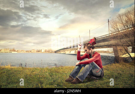 Arme Frau sitzen unter Brücke Stockfoto