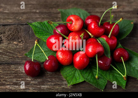 Kirschen. Saft-Sommerfrüchte mit frisch gepflückten Blätter Stockfoto