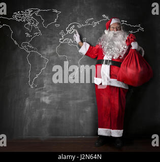 Santa Claus vor Weltkarte Stockfoto