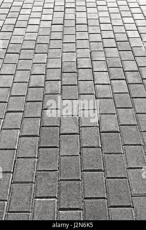 Graue Kopfsteinpflaster Bürgersteig Textur Hintergrund, große detaillierte vertikale graue Stein Pflasterdecke Perspektive, rau texturierte Cobble Muster Nahaufnahme Stockfoto