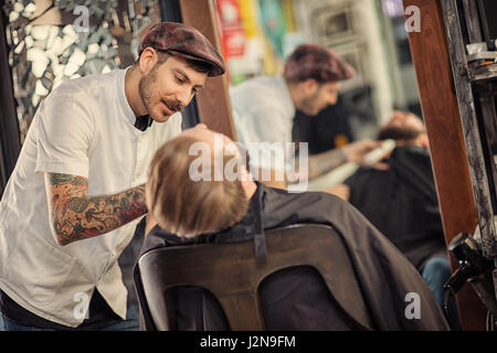 professionelle geschickte Barbier rasieren Bart an Kunden Stockfoto