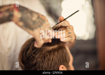 Haarschnitt beim Friseur mit einer Schere Stockfoto