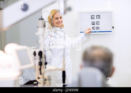 Schöne weibliche blonde Augenarzt zeigen Buchstaben im Raum consulting Stockfoto