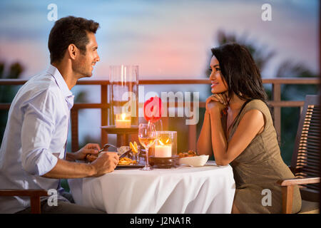 Paar Teilen romantische Abendessen bei Sonnenuntergangs auf tropischen resort Stockfoto