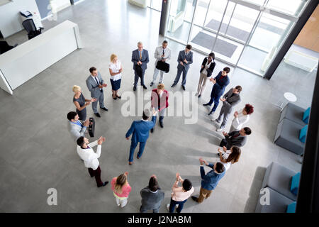Draufsicht auf Geschäftliches Arrangement und Händeschütteln von Geschäftsleuten im Mittelpunkt des Kreises Stockfoto