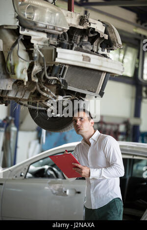 Versicherungs-Agent schreiben über Zwischenablage Bewertung auf Kfz-Schaden Stockfoto