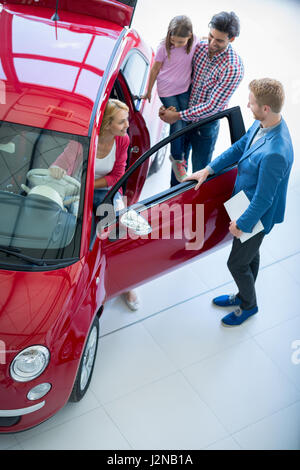 Junge Familie wählt für einen Autokauf im Autohaus Auto Salon Stockfoto