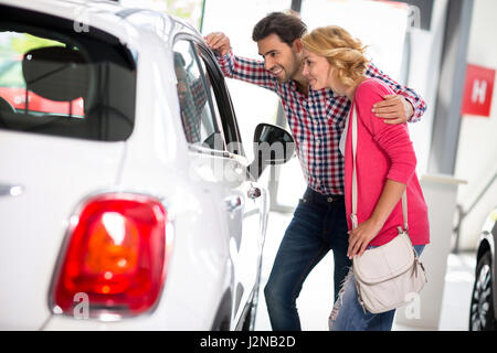 Junges Paar wählt für einen Autokauf im Auto Autohaus saloon Stockfoto