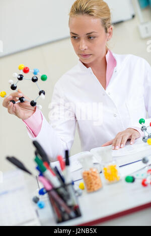 Junge weibliche Chemielehrer molekulare Struktur im Klassenzimmer zu beobachten Stockfoto