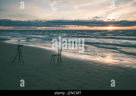 roter Stuhl am Strand am Morgen. Langzeitbelichtung geschossen. Lettland - Vintage-Effekt Stockfoto