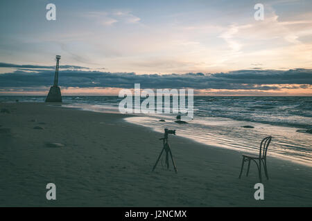 roter Stuhl am Strand am Morgen. Langzeitbelichtung geschossen. Lettland - Vintage-Effekt Stockfoto