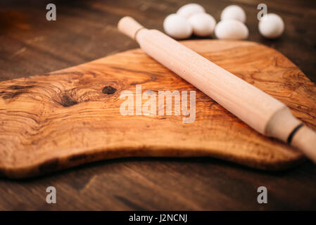 Schneidebrett, Nudelholz und Eiern auf hölzernen Hintergrund Detailansicht. Hausgemachtes Essen Koch-Konzept. Teig backen Stockfoto