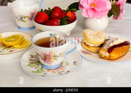 Tasse Tee serviert in einer Vintage Porzellan Teetasse mit Sahnetorten. Stockfoto