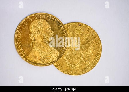 Nahaufnahme von zwei auf einander Austria-Hungary Taler, avers und Revers der goldenen Münze-Dukaten aus dem Jahr 1915 mit Kaiser Franz Joseph i., auf weißen bac Stockfoto