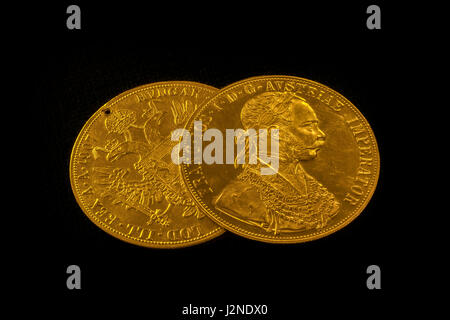 Nahaufnahme in der Perspektive von zwei auf einander Austria-Hungary Taler, avers und Revers der goldenen Münze-Dukaten aus dem Jahr 1915 mit Kaiser Franz Joseph Stockfoto