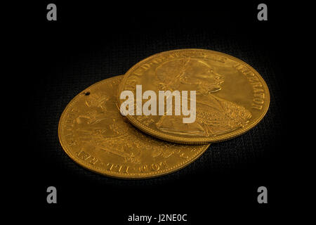 Nahaufnahme in der Perspektive von zwei auf einander Austria-Hungary Taler, avers und Revers der goldenen Münze-Dukaten aus dem Jahr 1915 mit Kaiser Franz Joseph Stockfoto