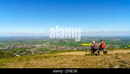 Zwei späte Männer mittleren Alters sitzen auf einer Bank, Blick über den Severn Valley vom oberen Rand der Malvern Hills. Stockfoto