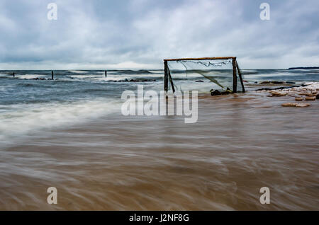 Sturm am Ostsee-Strand. Wasser umgeben von Fußballtor am Strand. Stockfoto