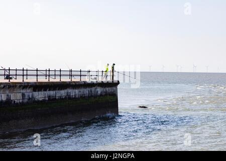 Herne Bay, Kent, UK. 29. April 2017. UK-Wetternachrichten.  Ein sonniger Abend am ersten Tag der Mayday Bank Holiday Wochenende ermöglicht es Menschen, die an den Strand zu gehen, obwohl sie gegen die Kälte verpackt bleiben.  Zwei Angler Fischen abseits den Pier in Hampton. Bildnachweis: Richard Donovan/Live Alamy News Stockfoto