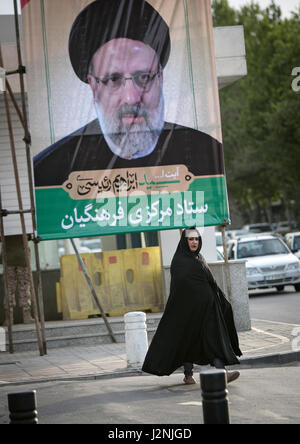 Teheran, Iran. 29. April 2017. Eine Frau geht vorbei ein Plakat des iranischen Präsidentschaftskandidaten Ebrahim Reisi an einer Straßenecke in Mashhad Stadt, nordöstlichen Iran am 29. April 2017. Iranische senior Principlist Kleriker, Ebrahim Reisi registriert für die bevorstehende Präsidentschaftswahl im Iran am 14. April. Bildnachweis: Ahmad Halabisaz/Xinhua/Alamy Live-Nachrichten Stockfoto