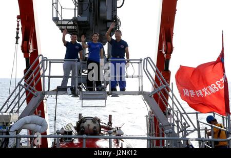 (170430)--an Bord Schiff XIANGYANGHONG 09, 30. April 2017 (Xinhua)--Crew Mitglieder und Wissenschaftler Tang Jialing, Zhang Yi und Shi Xuefa (L-R) Welle nach der Durchführung einer Tauch-Mission an Bord Jiaolong, Chinas bemannte u-Boot, in das Südchinesische Meer, Süd-China, 29. April 2017. Jiaolong durchgeführt seinen dritten Tauchgang Samstag in das Südchinesische Meer in der zweiten Phase von Chinas 38. Ozean wissenschaftliche Expedition. Neun Stunden und 35 Minuten im Wasser zu verbringen, wurde die maximale Tiefe der Jiaolong Arbeit diesmal 2.930 Meter unter dem Meeresspiegel. (Xinhua/Liu Shiping) (Ry) Stockfoto