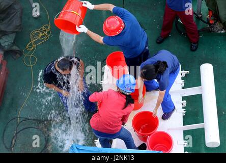 (170430)--an Bord Schiff XIANGYANGHONG 09, 30. April 2017 (Xinhua)--A Scientist (1. L) wird bei einer Wasserplätschern Zeremonie nach der Durchführung einer Tauch-Mission an Bord Jiaolong, Chinas bemannte u-Boot, in das Südchinesische Meer, Süd-China, 29. April 2017 begrüßt. Jiaolong durchgeführt seinen dritten Tauchgang Samstag in das Südchinesische Meer in der zweiten Phase von Chinas 38. Ozean wissenschaftliche Expedition. Neun Stunden und 35 Minuten im Wasser zu verbringen, wurde die maximale Tiefe der Jiaolong Arbeit diesmal 2.930 Meter unter dem Meeresspiegel. (Xinhua/Liu Shiping) (Ry) Stockfoto