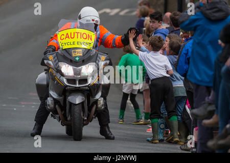 Ein Polizeimotorradfahrer macht eine Pause von Le Tour 2017 bis High Five ein kleiner Junge beobachtet die Tour, wie sie durch das Dorf Linton vor dem Hauptfeld passiert Stockfoto