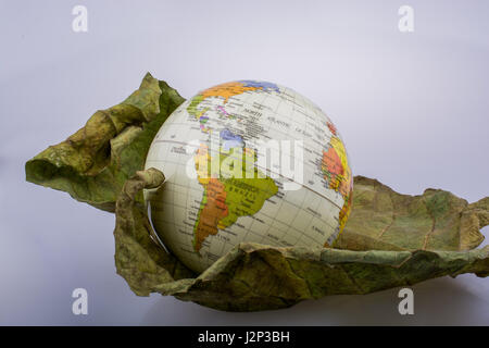 Kleiner Globus platziert auf trockenen Herbstblatt Stockfoto