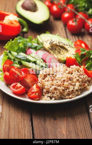 Buddha-Schüssel mit Mischung aus Gemüse, Quinoa auf hölzernen Hintergrund Stockfoto