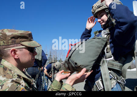 Armee 1st Lt. Matthew Sneddon, 1. Bataillon, 501st Fallschirm-Infanterie-Regiment-Luft-Offizier und gebürtig aus Fayetteville, NC, inspiziert Eagle River High School Air Force Junior ROTC Cadet Riley Sheldon bevor die High-School-Schüler von einem 34-Fuß-Sprung-Turm 19. April 2017, bei der gemeinsamen Basis Elmendorf-Richardson Airborne Sustainment Trainingsbereich springt. Viele der gleichen Sicherheits-Checks für eine tatsächliche Fallschirmsprung verwendet werden verwendet für Sprung Turm Ausbildung. Sheldon ist die Tochter von Sgt. Major Ronald Sheldon, der 673d Air Base Wing-Sergeant-Major. (Foto: David Bedard US Air Force) Stockfoto