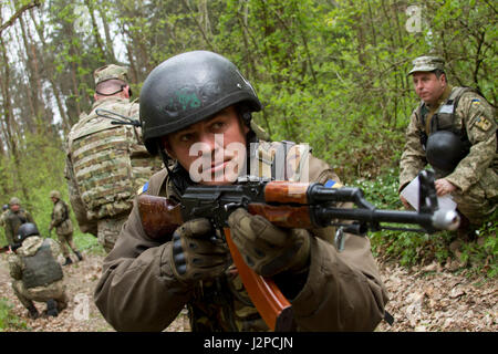 Eine ukrainische Soldaten und Student an der Yavoriv GÜZ Beobachter Controller Trainer Akademie sorgt für Sicherheit während einer situativen Übung auf die Yavoriv CTC International Peacekeeping und Security Center in der Nähe von Yavoriv, Ukraine, am 20. April.   Academy Studenten nahmen sich als ÜLG und wurden betreut von ukrainischen und US-Soldaten, Joint Multinational Training Group - Ukraine zugewiesen. Die JMTG-U-Mission soll helfen, die CTC Fähigkeiten und Professionalität in das ukrainische Militär bauen. (Foto von Sgt. Anthony Jones, 45. Infanterie Brigade Combat Team) Stockfoto